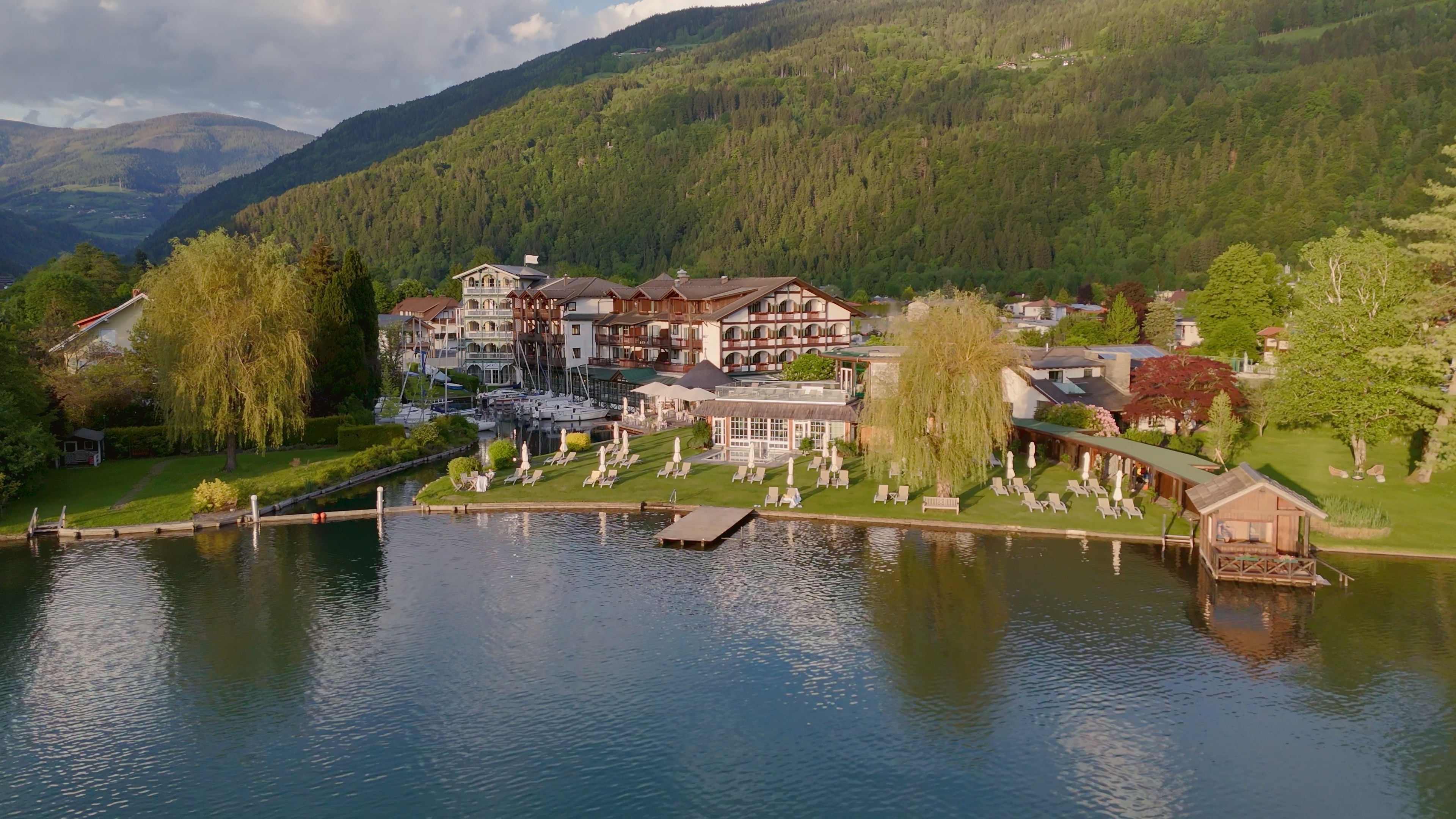 Ein Panoramabild des Hotel Seefischers mit Blick auf See und Berge.